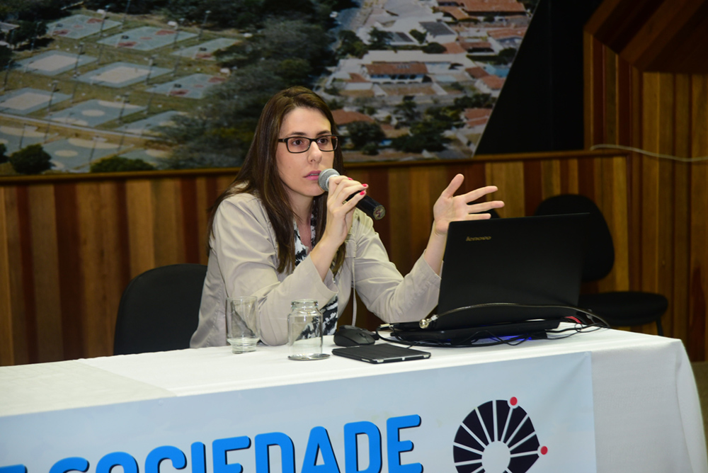 A jornalista Sabine Righetti, colunista do jornal Folha de S. Paulo, fala ao microfone em mesa do Simpósio "Comunicação: Universidade e Sociedade"