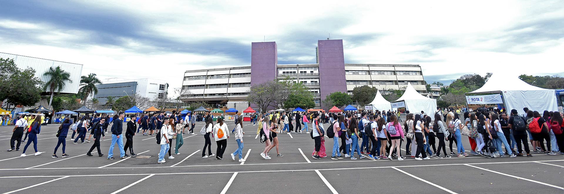 imagem colorida, filas de visitantes ao chegarem no estacionamento da Biblioteca Central