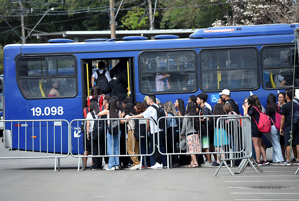 imagem colorida, visitantes embarcando em ônibus. 