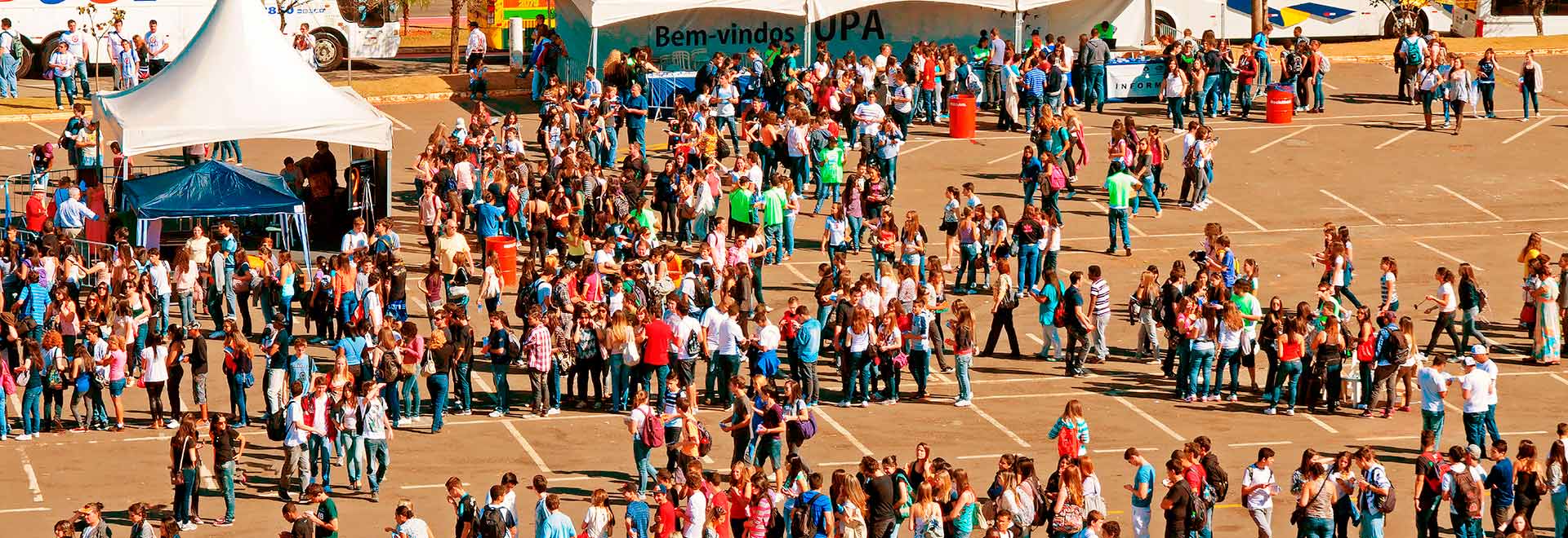 imagem colorida, visitantes  ao redor dos estandes do estacionamento da Biblioteca Central