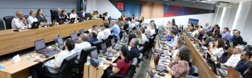 Imagem colorida: na sala de reunião do Consu, o reitor e os pró-reitores estão com os participantes do conselho.