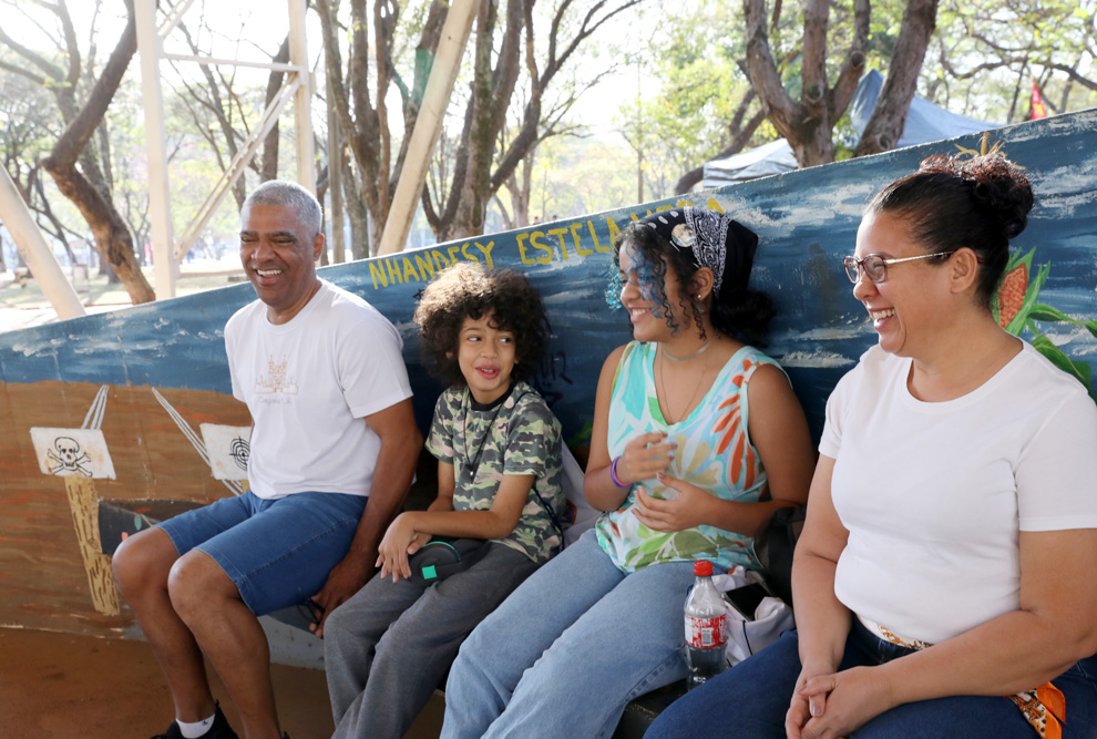 A haitiana Rosterline Romain e amigos (à esquerda), as amigas Ana Júlia Oliveira Silva e Evelyn Barboza Ferreira (ao centro) e o sociólogo Pedro Henrique Cunha da Silva e sua família