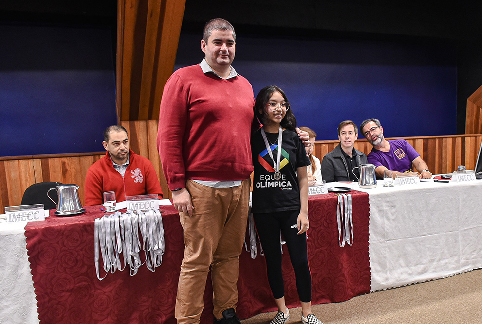 André Paschoalino Mengue e Mariana H. A. Ichiba receberam a medalha das mãos de Eliana Souza, da Diretoria de Ensino e do diretor do Imecc, Ricardo Martins, respectivamente  