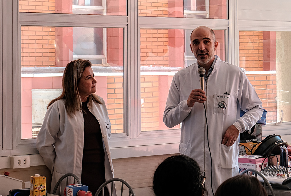 À esquerda, personagem Maria Clot distribui brindes para pacientes; à direita os professores da FCM Joyce Maria Annichino e Erich Vinicius de Paula 