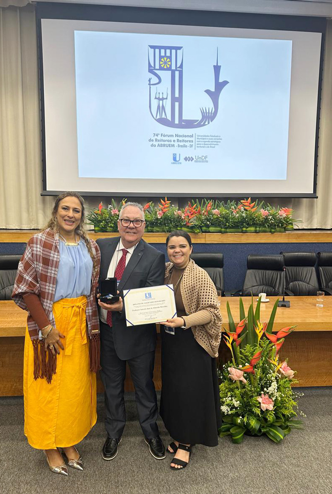 O reitor Paulo Cesar Montagner ao receber o diploma de homenagem a Antonio Meirelles