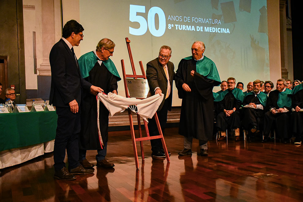 Cerimônia foi marcada por reencontros e homenagens; à esquerda placa é descerrada e à direita o reitor Paulo Cesar Montagner cumprimenta o hematologista Carmino Antônio de Souza